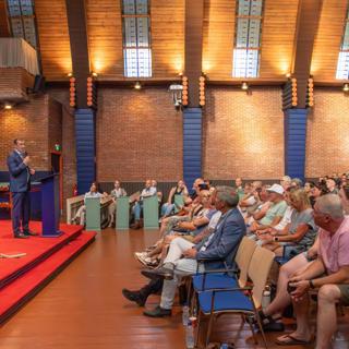 Bewoners steenstripwoningen en Patrimoniumstraat luisteren naar staatssecretaris Eddie van Marum in MFC Kabzeël in Appingedam