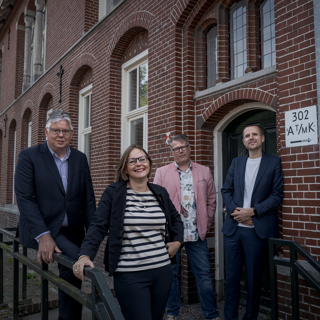 Karel Zuidema (Wender), Laura Broekhuizen (Groninger Huis), wethouder Evert Offereins (gemeente Midden-Groningen) en Anne de Vries (Kwartier Zorg & Welzijn) voor Het Oude Postkantoor.